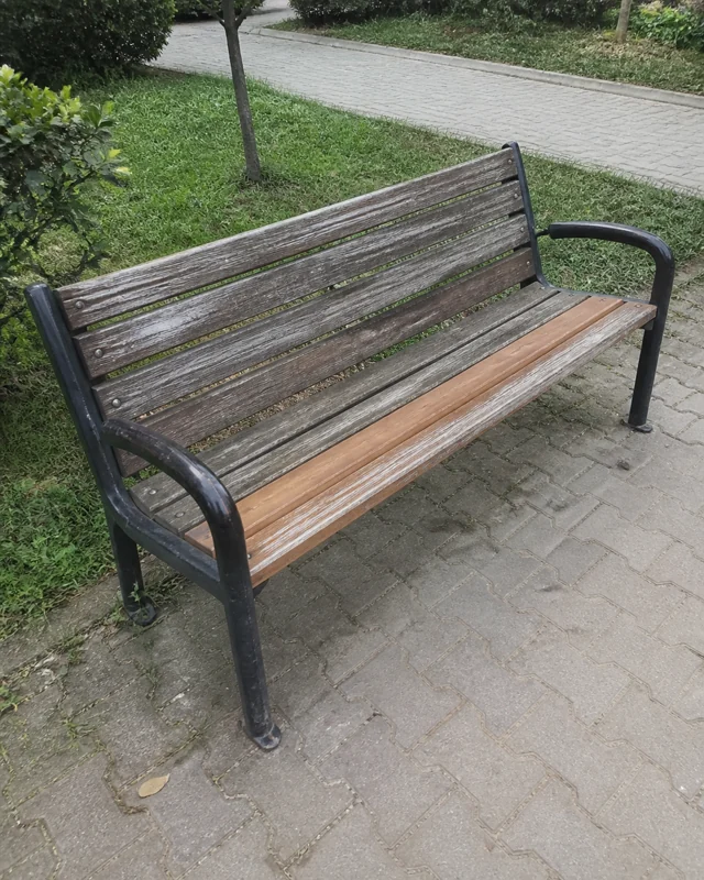 Oturma tahtası yenilenmiş, kullanılabilir durumdaki park bankı