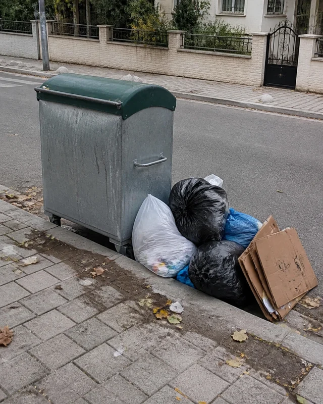 Çöp konteynerinin yanında biriken atık poşetleri ve kartonlar